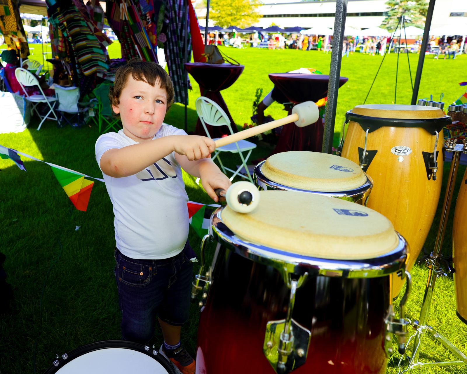 A young boy playing congas with mallets