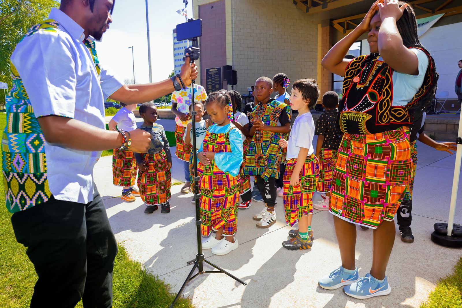 Dancers warming up in costume while the performance is filmed on a tripod