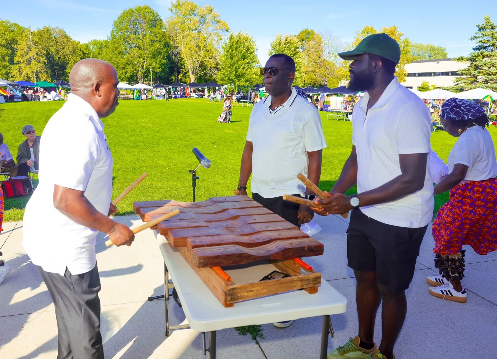 Musicians playing a large wooden xylophone on the festival grounds